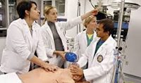 A group of doctors are standing around an operating table.