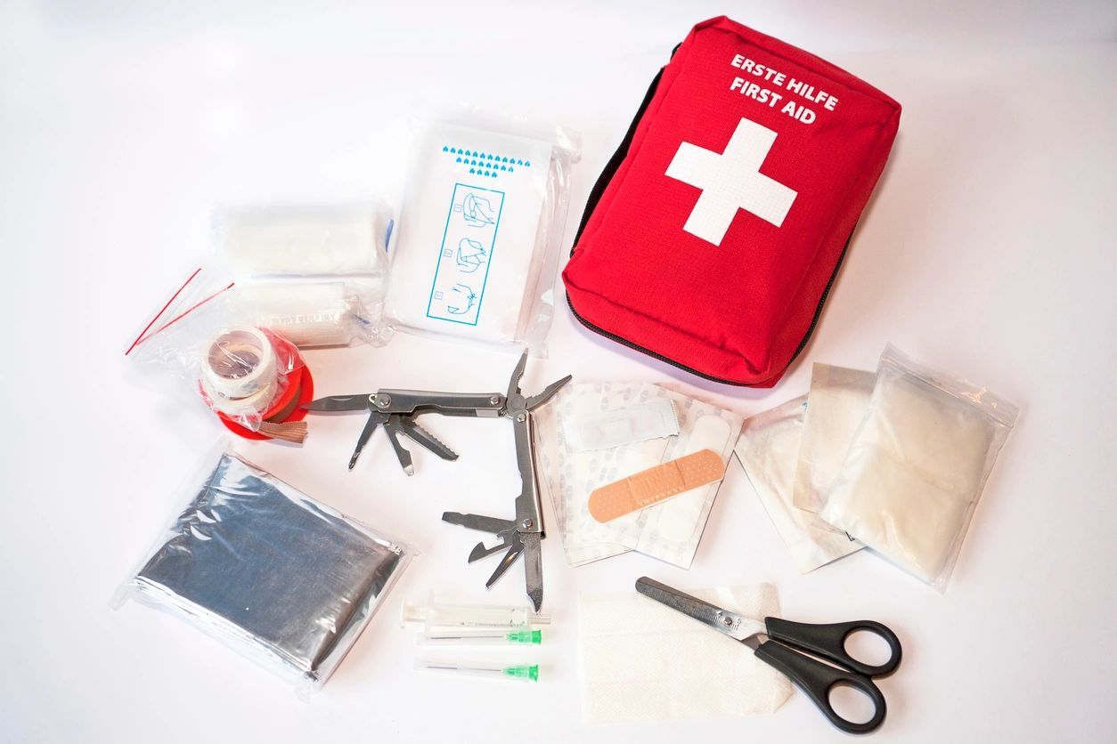 A red first aid kit with many items on it.