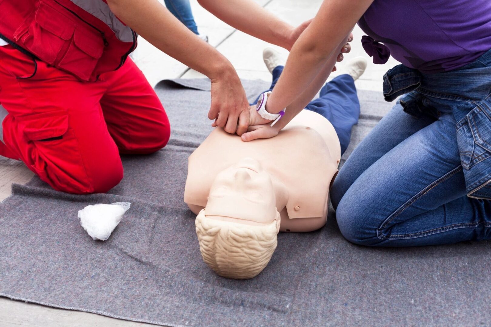 A person is performing cpr on an infant dummy.