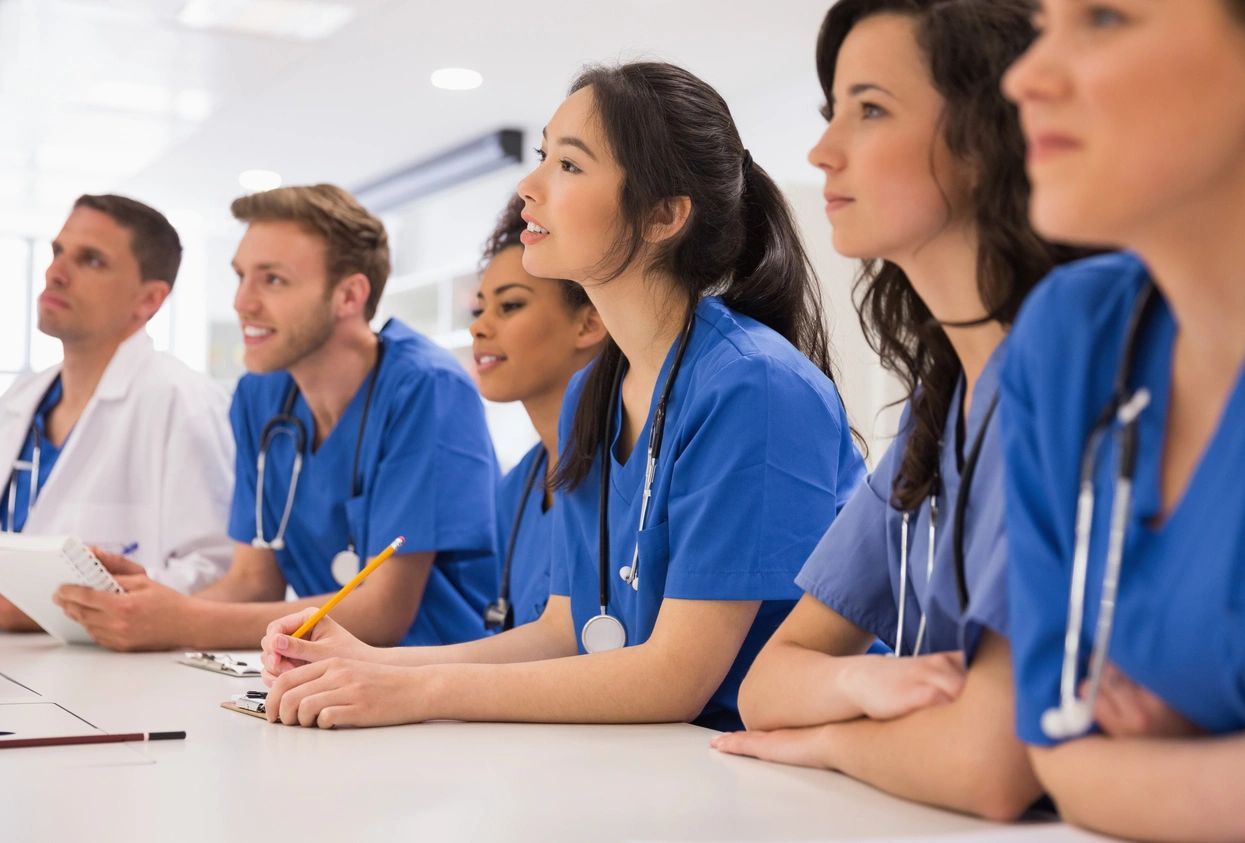 A group of doctors sitting in front of a table.